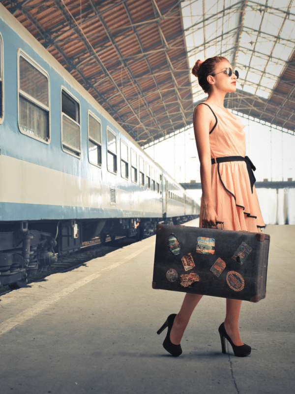 woman on train platform with suitcase all-inclusive vacations for singles over 50
